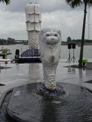 A smaller merlion with the large one behind it.